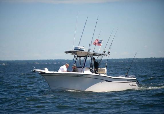 Tim Huff, far right, and Anthony Gisondi, left, fish with National Guard veteran Tom Kowolenko, center, on Saturday, June 21, 2014, during Halloween Yacht Club's third annual fishing tournament fundraiser, Hooks for Heroes, which this year supported Operation Gift Cards with proceeds going to veterans at Walter Reed Army Medical Center. Photo: Lindsay Perry / Stamford Advocate