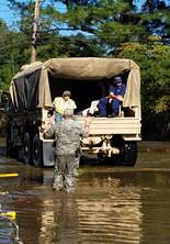 Master Chief Petty Officer Louis Coleman (right) sits with flood survivors and rescuers on a North Carolina Air National Guard 236th Brigade Engineer Battalion M35 2&frac12;-ton cargo truck in Lumberton, North Carolina, Oct. 10, 2016. The Lumber River flooded the city after Hurricane Matthew. (U.S. Coast Guard photo by Petty Officer 1st Class James Prosser/Released)